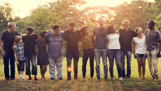 Un groupe diversifié de personnes qui se tiennent ensemble et qui sourient