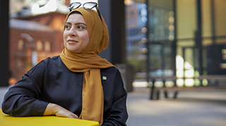 Un collègue de la TD accueille une cliente en succursale avec le sourire afin de discuter de ses finances.